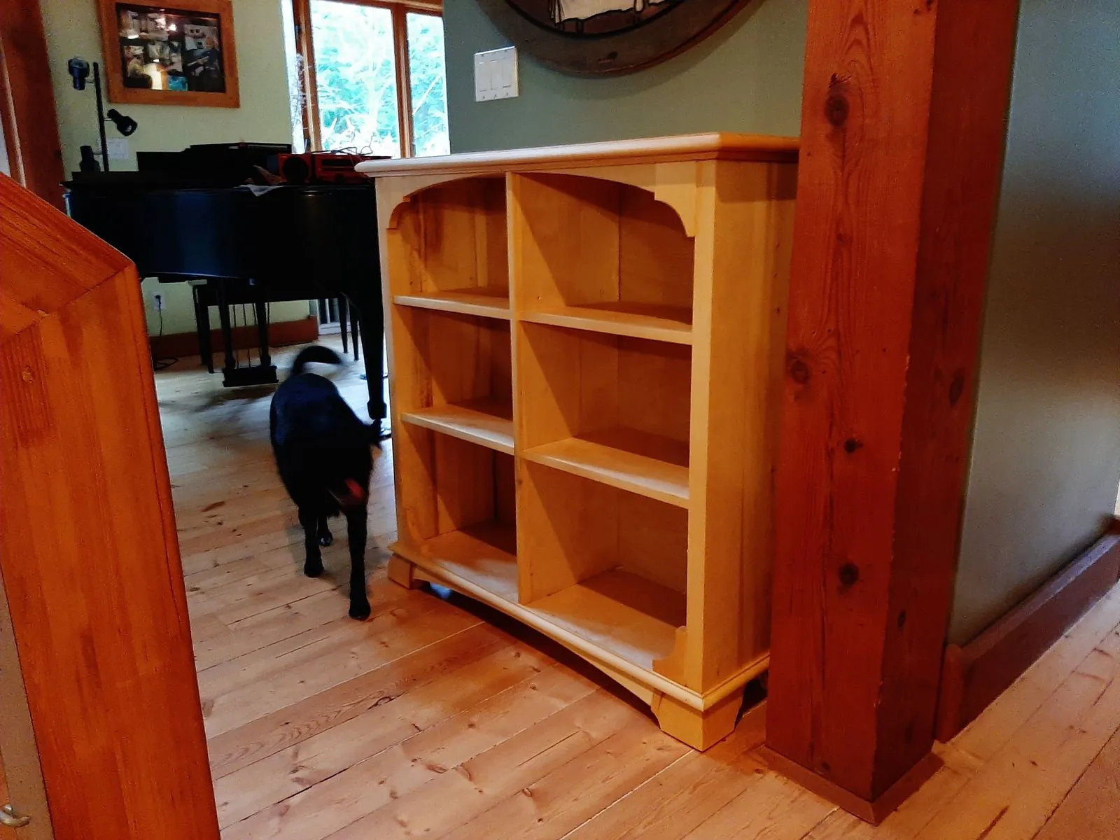 A built bookcase in solid pine standing in a room