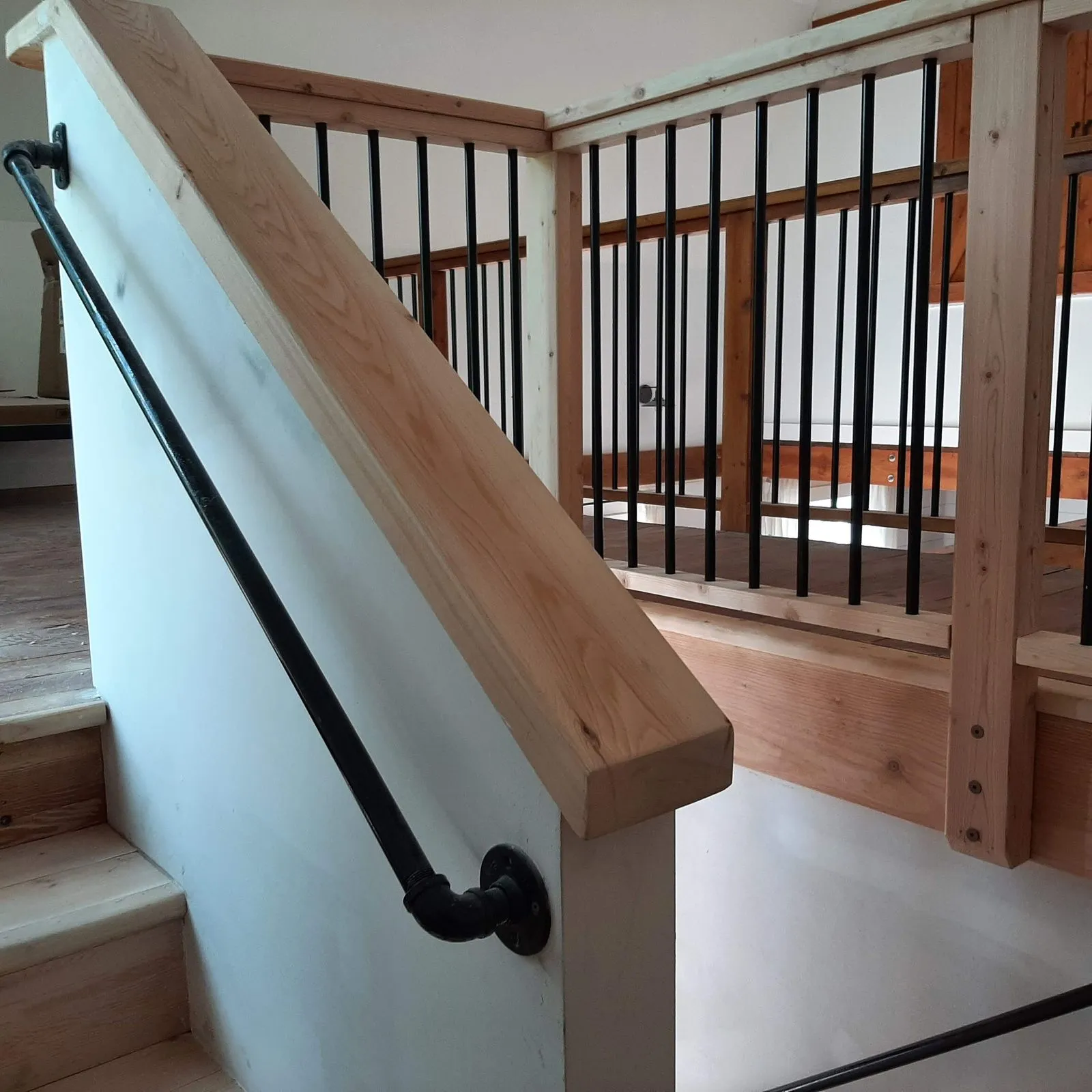 An interior stair railing in timber with metal balusters