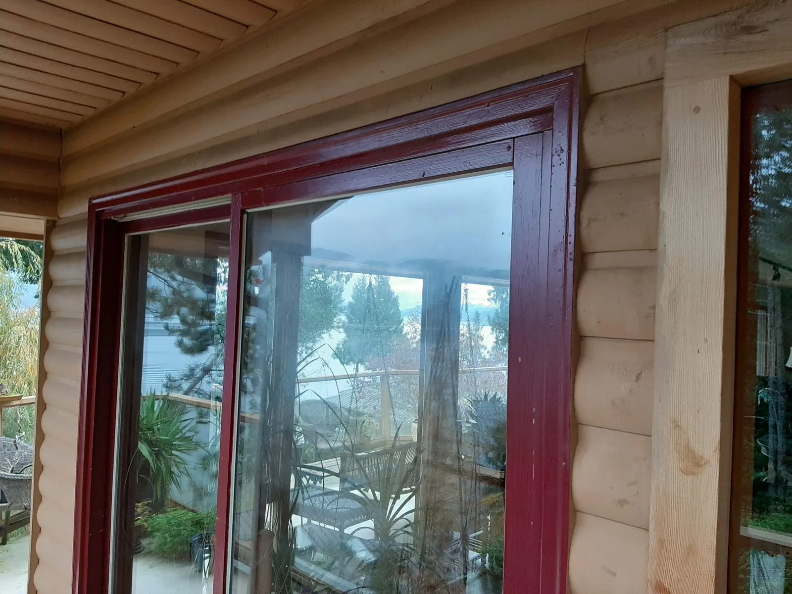 A patio door framed with timber trim scribed into a log wall