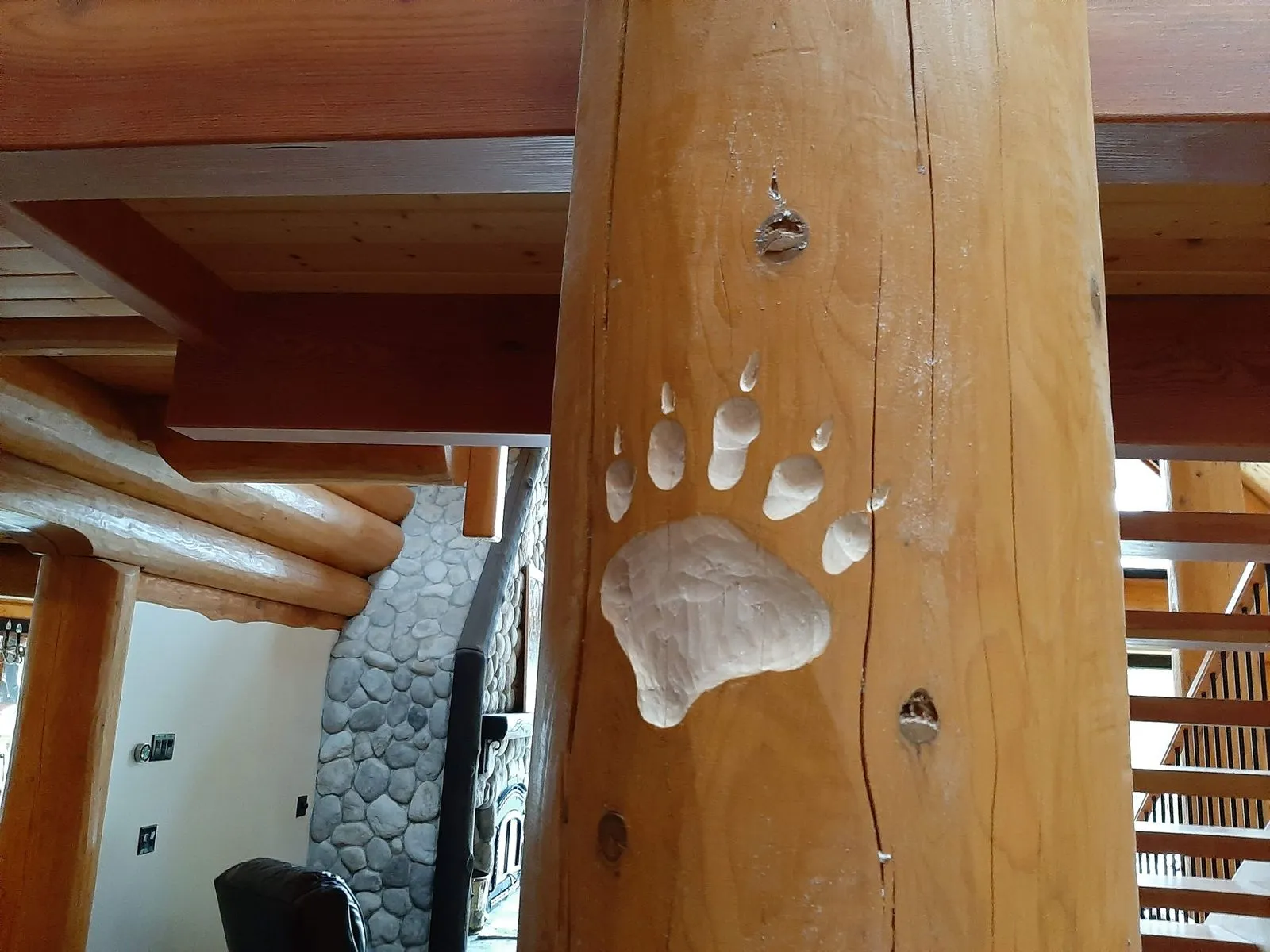 A bear paw print carved into a log post