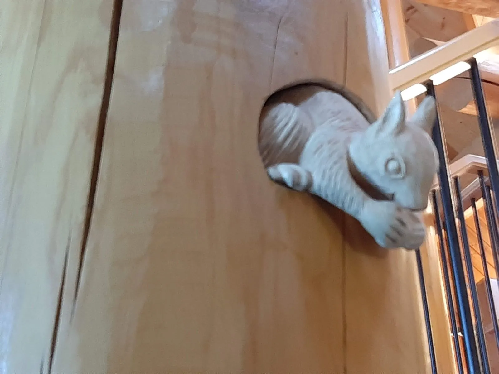 A carved squirrel corbel mounted on a log post
