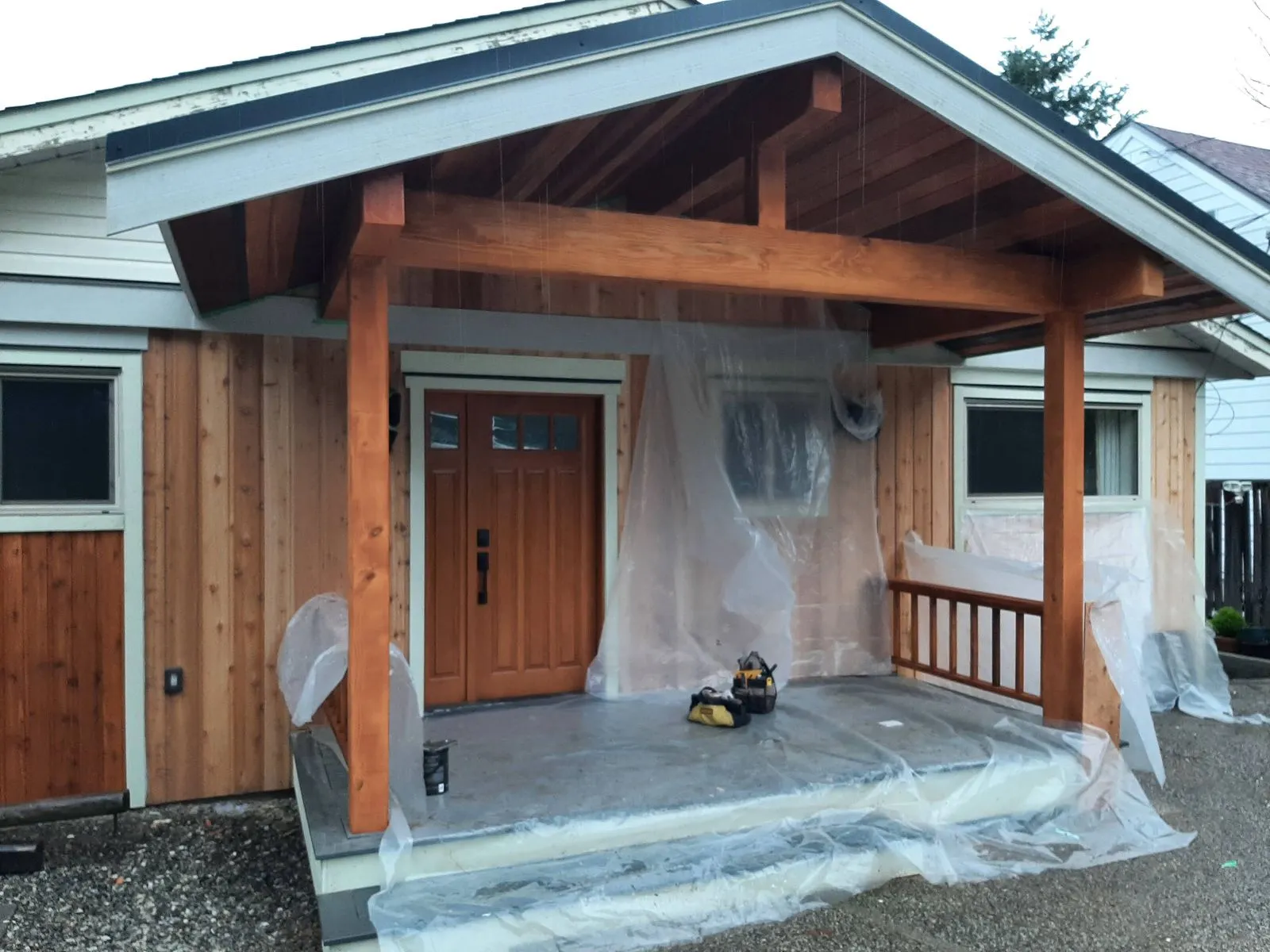 A covered entry porch with timber posts and beams