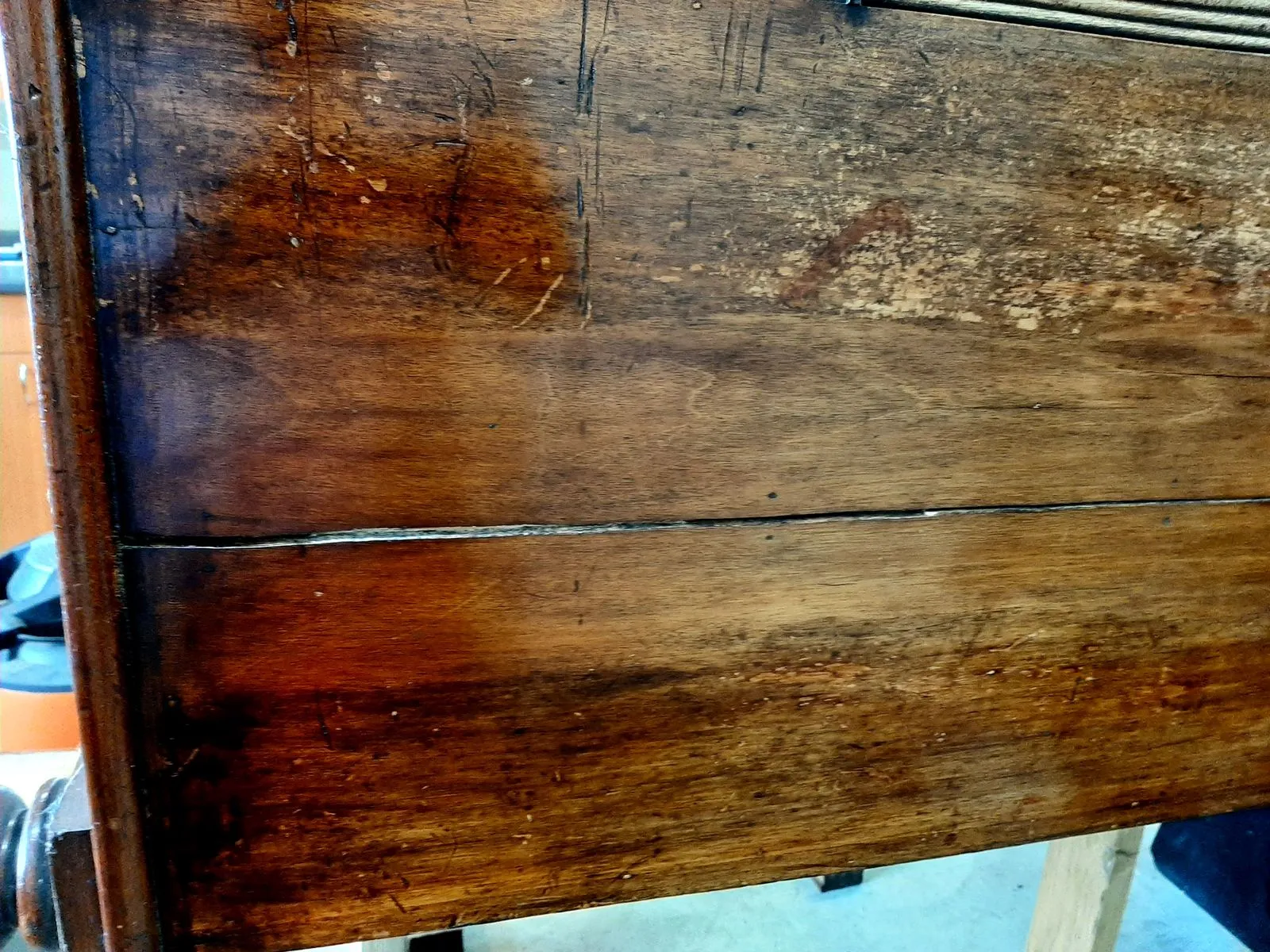 A mahogany chest of drawers before restoration, water-stained and lifting