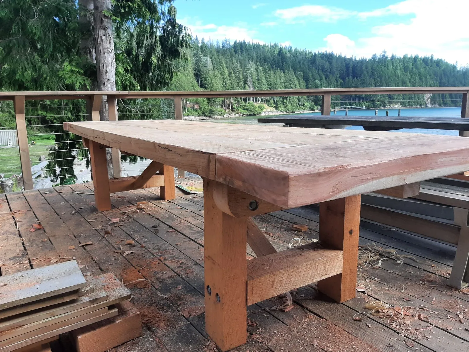 A heavy timber trestle dining table on a deck