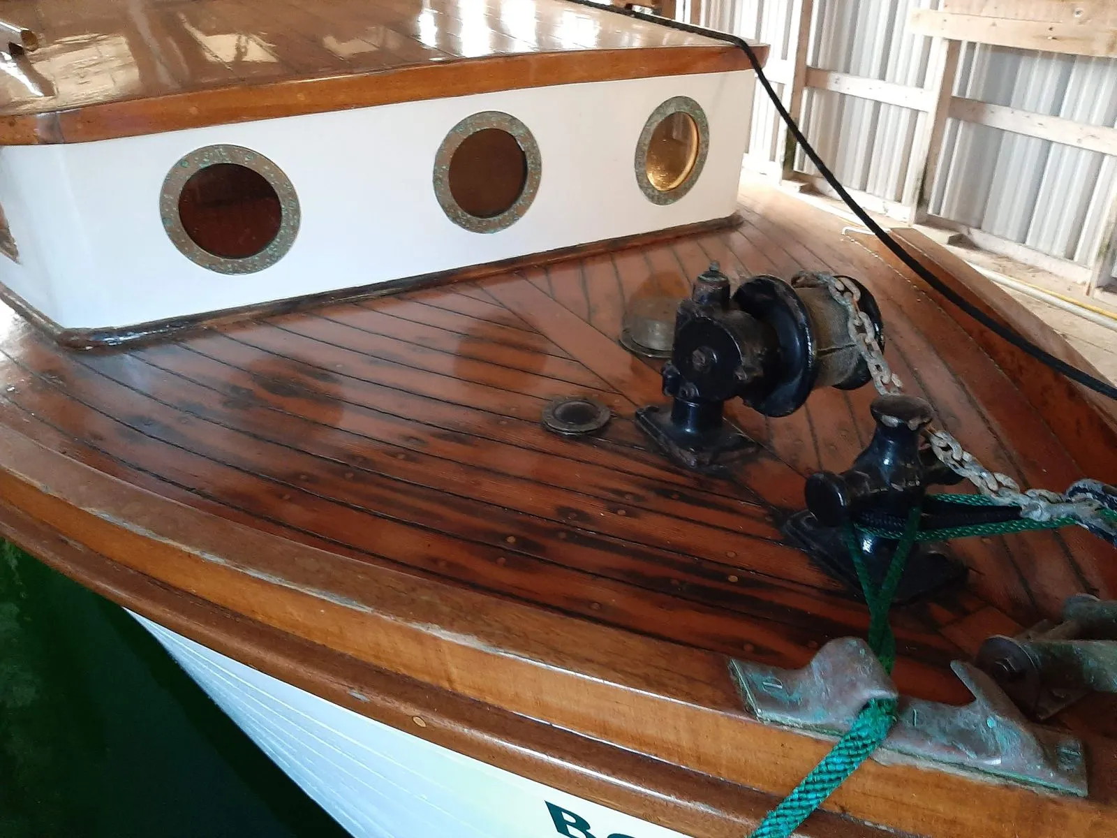 The varnished teak foredeck of a restored classic wooden vessel