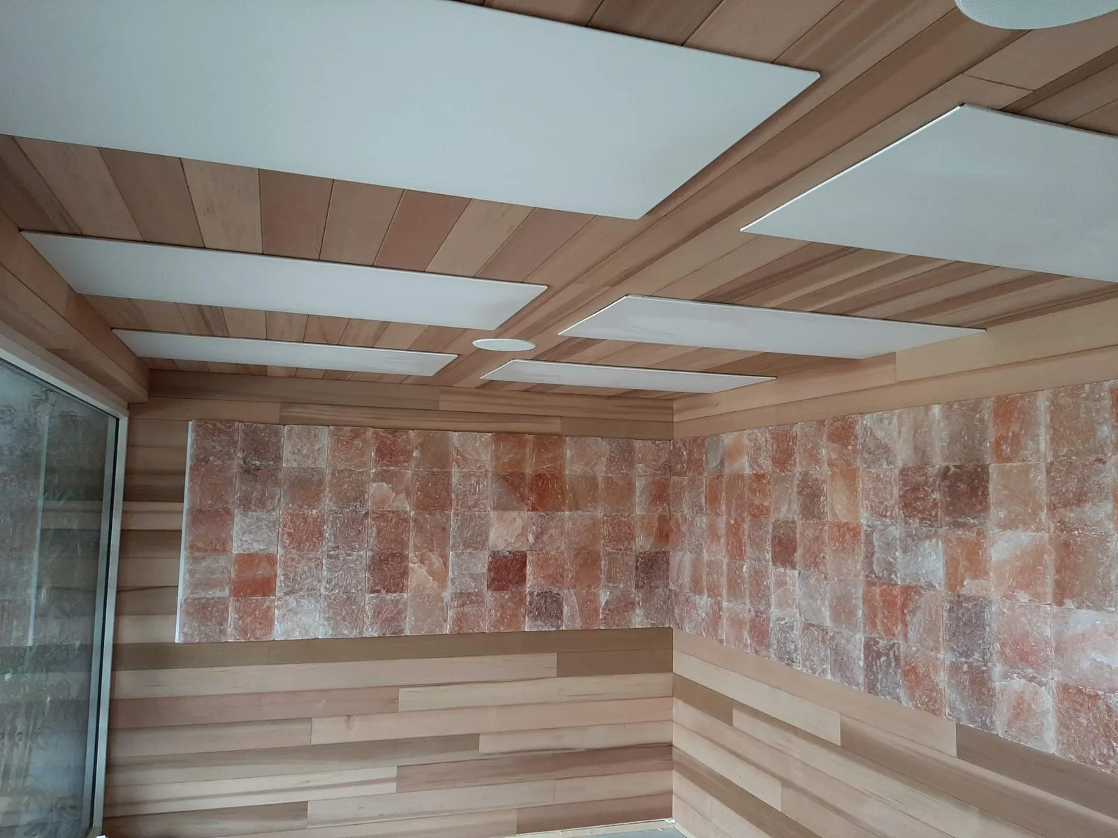 A sauna lined in cedar with a coffered beam ceiling