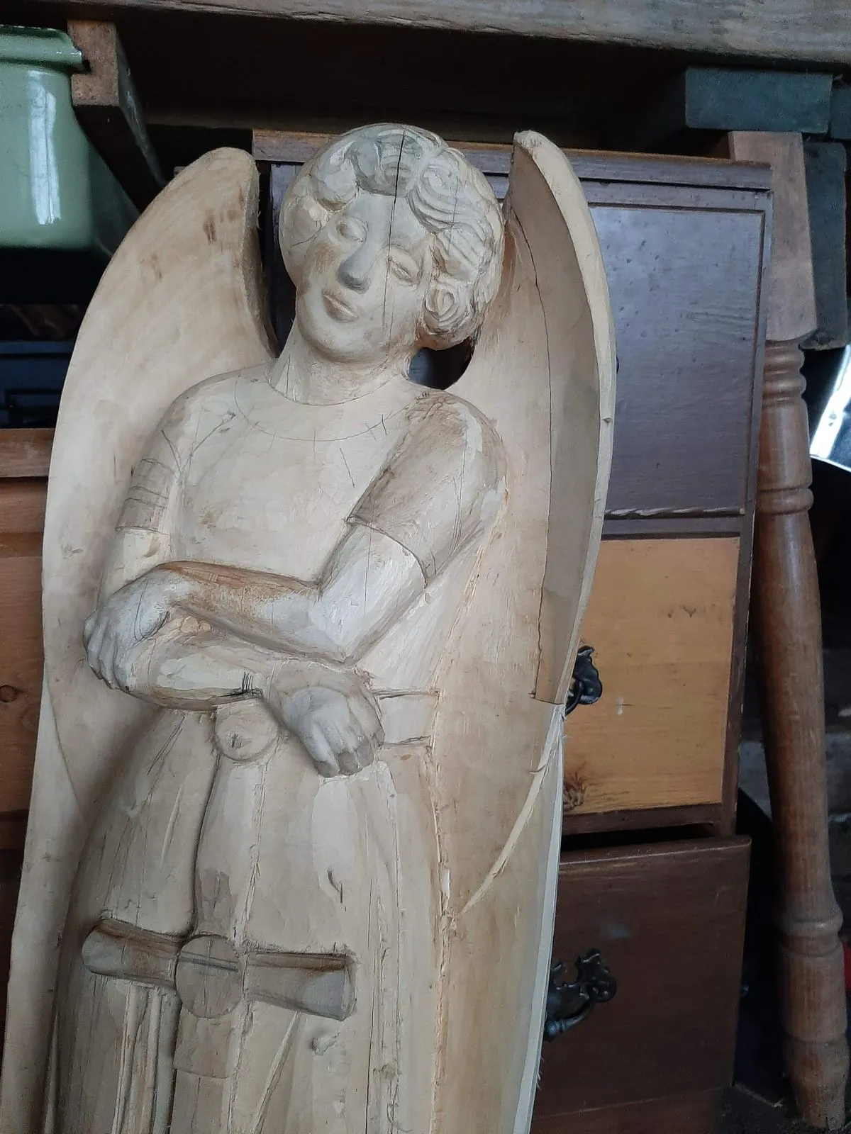 A carved figure in relief within an arched wooden panel