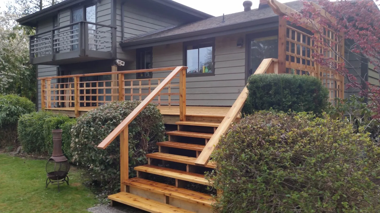 A rebuilt cedar deck with stairs, railing and a trellis screen